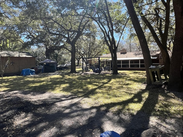 111 Newington Rd, Summerville, SC 29485 - view of yard featuring a sunroom, an outdoor structure, and a storage shed