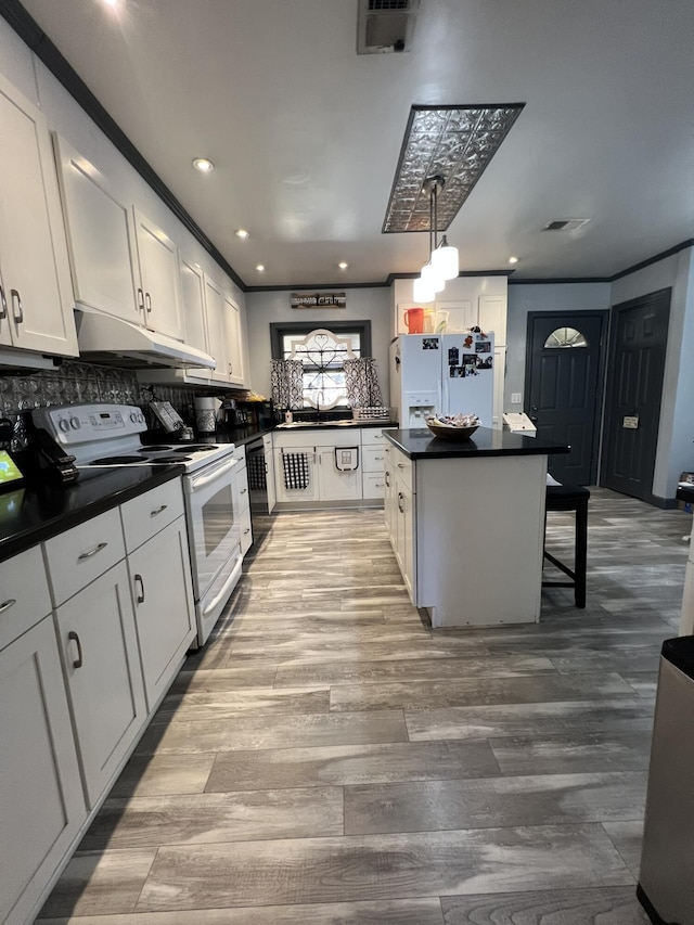 111 Newington Rd, Summerville, SC 29485 - kitchen with white appliances, white cabinets, dark countertops, wood finished floors, and under cabinet range hood