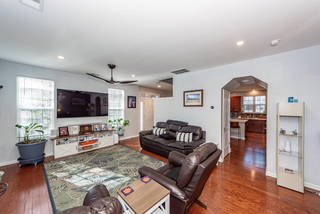 living room featuring ceiling fan, dark hardwood / wood-style flooring, and a wealth of natural light