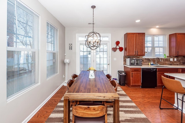 dining room featuring sink, light hardwood / wood-style flooring, and a notable chandelier