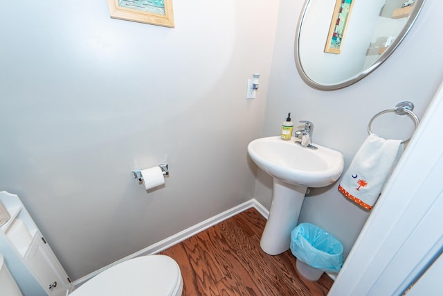 bathroom with toilet and hardwood / wood-style floors