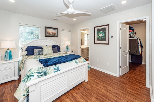 bedroom with ceiling fan, dark wood-type flooring, and connected bathroom