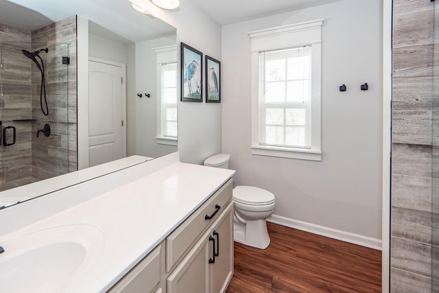 bathroom with hardwood / wood-style floors, an enclosed shower, vanity, and toilet