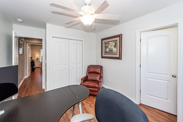 home office with ceiling fan and dark wood-type flooring