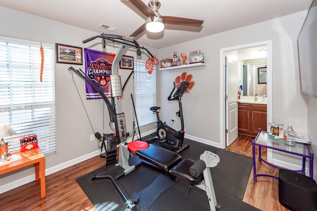 workout room with ceiling fan and dark wood-type flooring