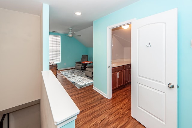 corridor featuring vaulted ceiling and dark hardwood / wood-style floors