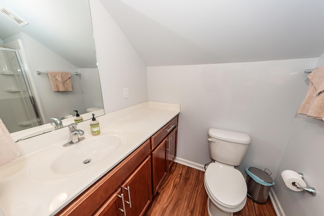 bathroom with lofted ceiling, vanity, toilet, wood-type flooring, and a shower with door