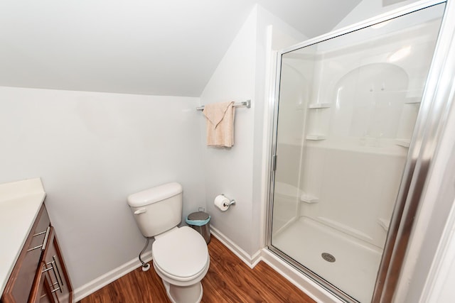 bathroom with toilet, hardwood / wood-style floors, lofted ceiling, walk in shower, and vanity