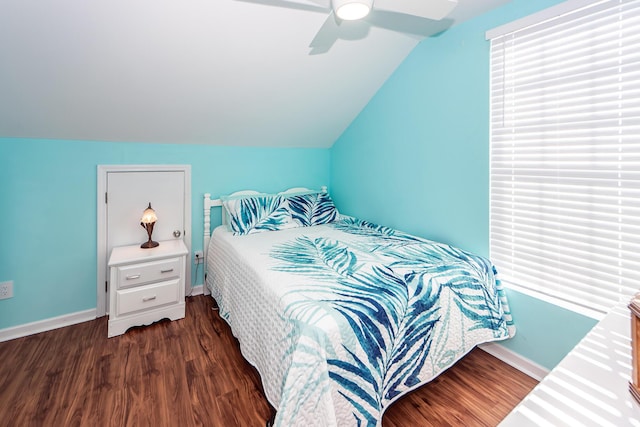 bedroom featuring ceiling fan, dark wood-type flooring, multiple windows, and vaulted ceiling