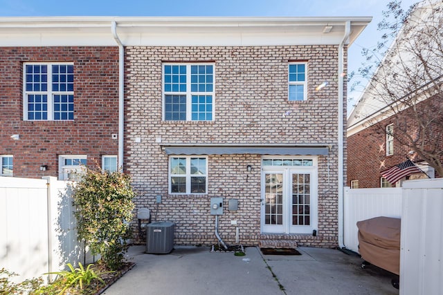 back of property with central air condition unit and a patio area