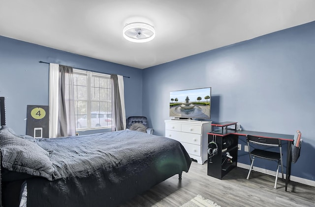 bedroom with baseboards and wood finished floors