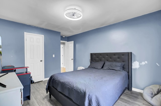 bedroom with baseboards and wood finished floors