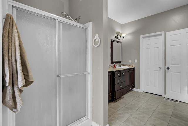 full bathroom with a stall shower, tile patterned flooring, visible vents, and vanity