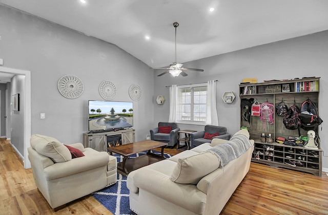 living room featuring lofted ceiling, ceiling fan, wood finished floors, a fireplace, and recessed lighting