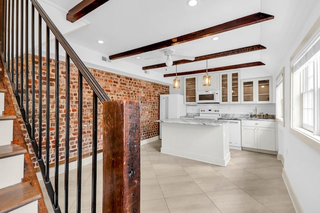 kitchen featuring pendant lighting, a center island, white appliances, white cabinets, and beamed ceiling