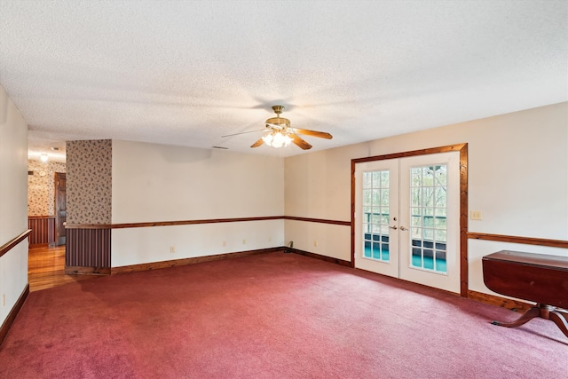 empty room featuring ceiling fan, carpet floors, a textured ceiling, and french doors