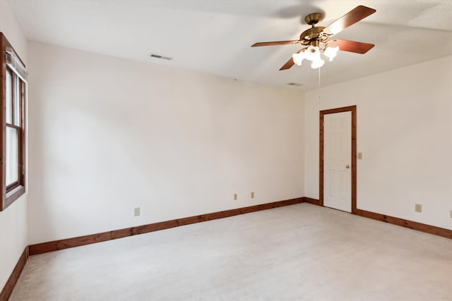 carpeted spare room with ceiling fan