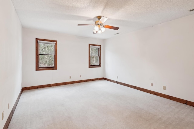 carpeted empty room featuring ceiling fan and a textured ceiling