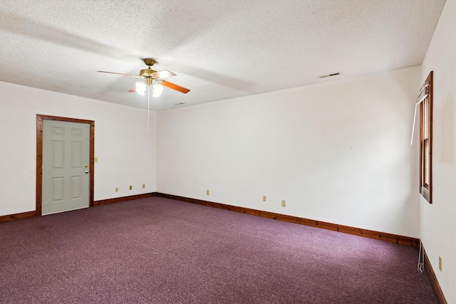 empty room with dark colored carpet, ceiling fan, and a textured ceiling