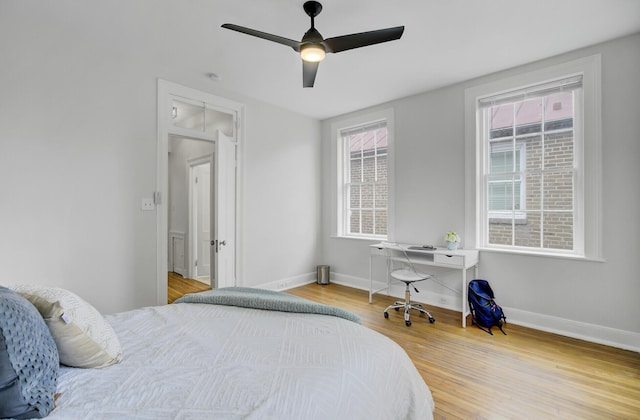 bedroom with hardwood / wood-style flooring, ceiling fan, and multiple windows