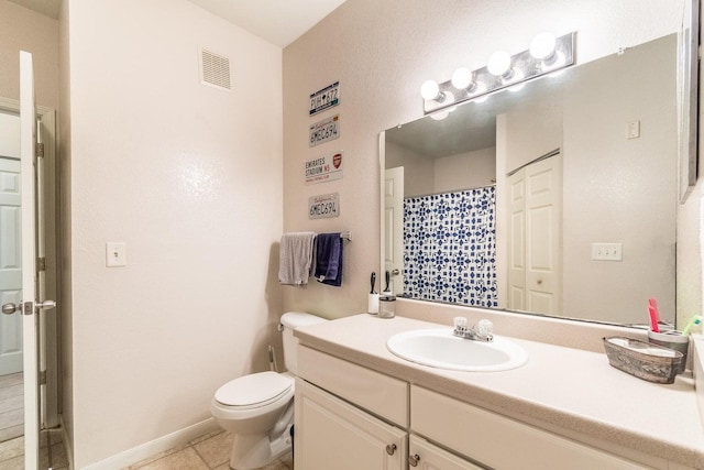 bathroom featuring tile patterned flooring, vanity, and toilet