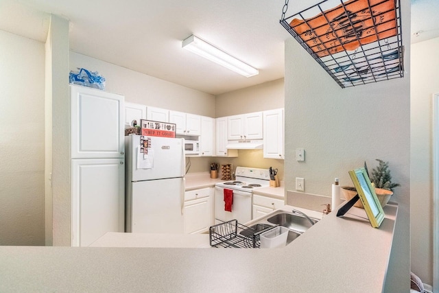 kitchen with white cabinets, white appliances, kitchen peninsula, and sink