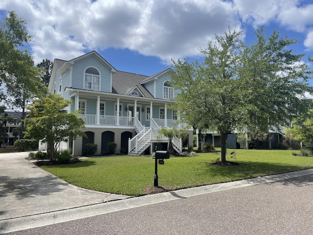 view of front of property featuring driveway, a porch, stairway, and a front yard
