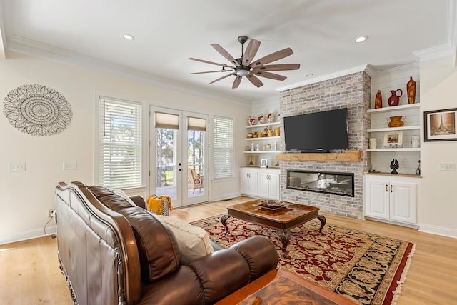 living room featuring baseboards, a ceiling fan, and light wood finished floors
