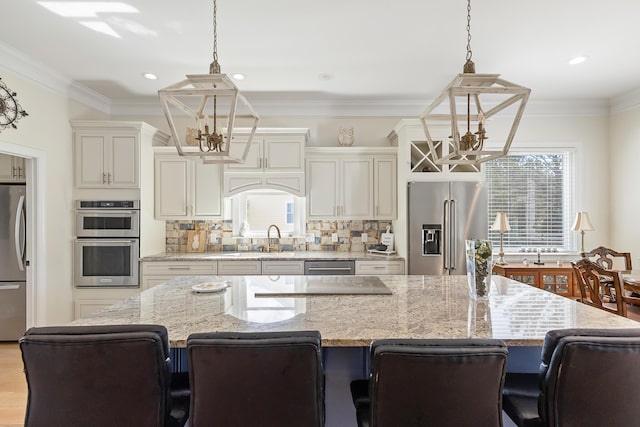 kitchen featuring an inviting chandelier, a center island, a sink, a wealth of natural light, and stainless steel appliances