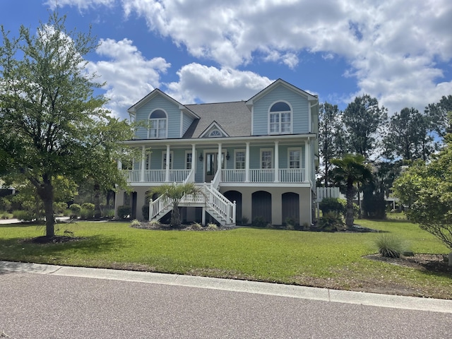 raised beach house featuring stairs, a porch, and a front lawn