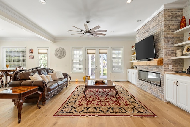 living area with crown molding, a brick fireplace, french doors, a ceiling fan, and light wood finished floors
