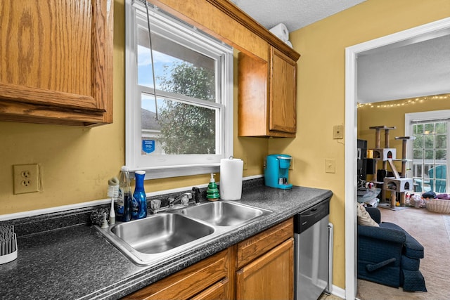 kitchen with sink, a textured ceiling, dishwasher, and carpet flooring