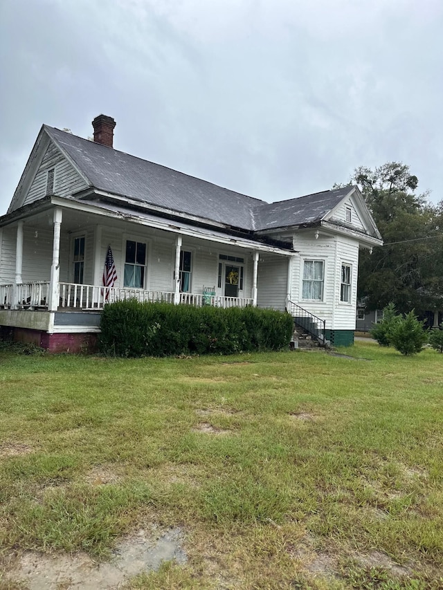 view of front of house with a porch and a front lawn