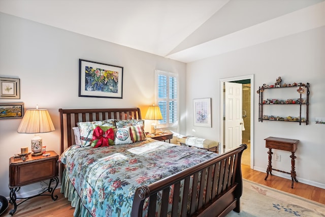 bedroom with hardwood / wood-style floors and vaulted ceiling