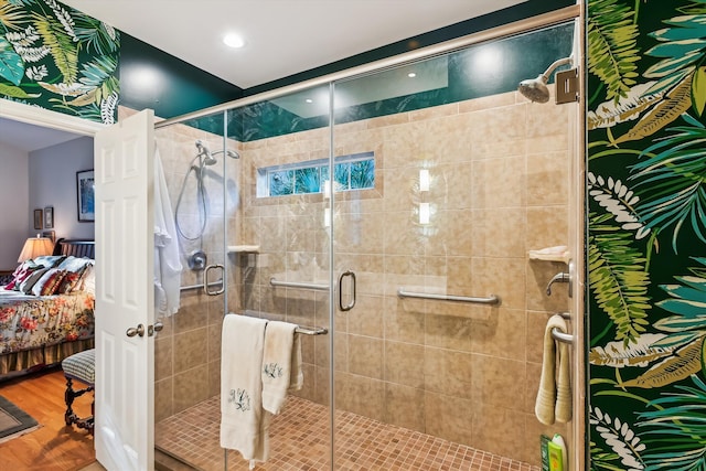 bathroom with hardwood / wood-style floors and a shower with shower door