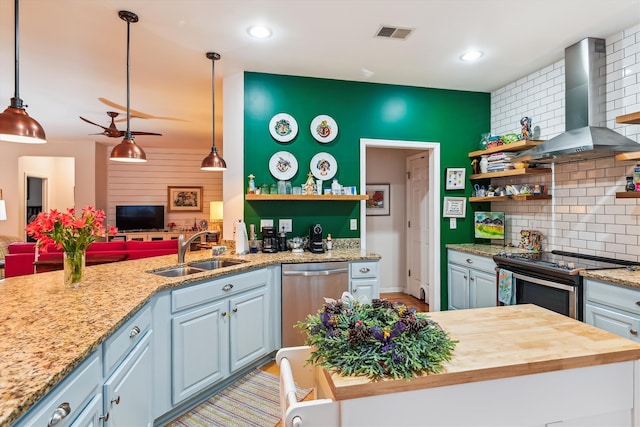 kitchen featuring sink, wall chimney exhaust hood, stainless steel appliances, and wood counters