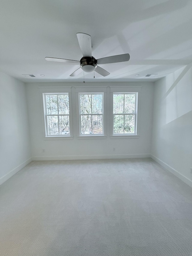 carpeted empty room with plenty of natural light and ceiling fan