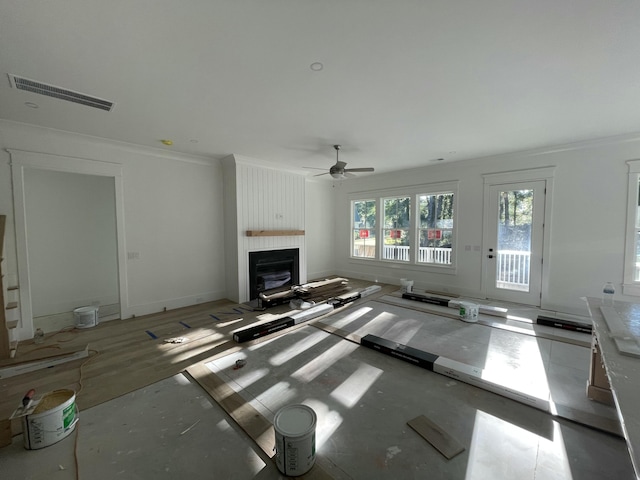 unfurnished living room featuring ceiling fan, ornamental molding, and a fireplace