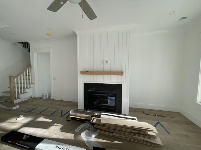 living room featuring ceiling fan, a fireplace, and light hardwood / wood-style flooring