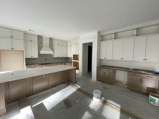 kitchen featuring built in desk and wall chimney exhaust hood