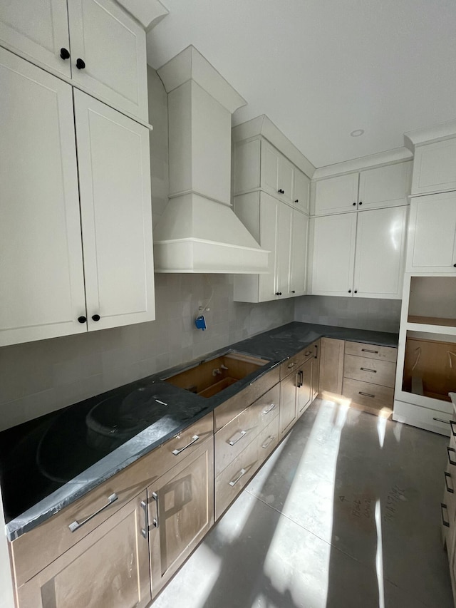 kitchen with decorative backsplash, custom range hood, and white cabinets