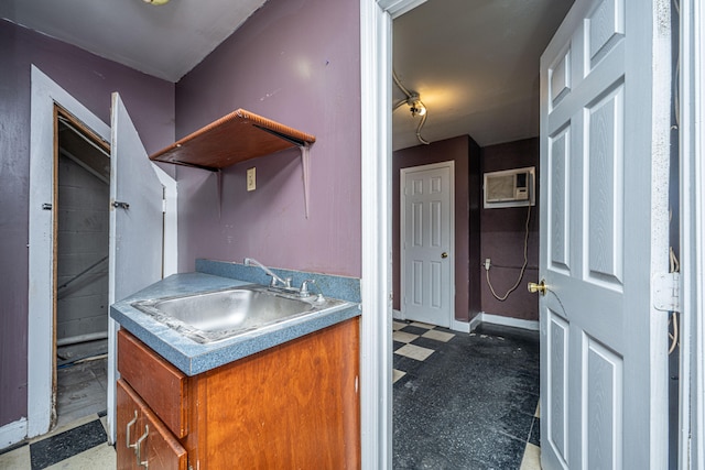 kitchen featuring a wall unit AC and sink