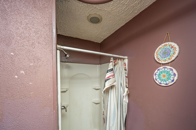 details featuring a textured ceiling and walk in shower