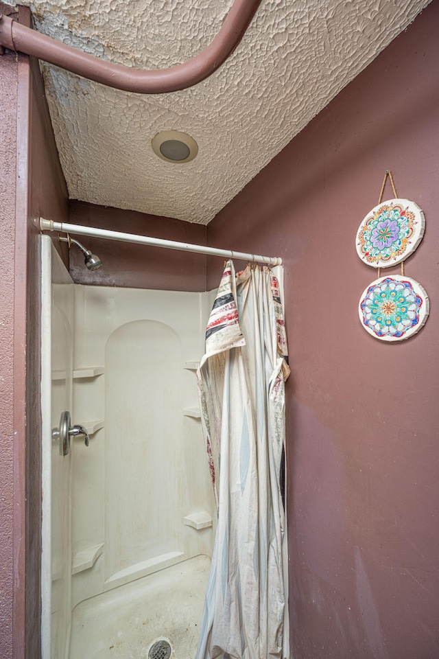 bathroom with a textured ceiling and walk in shower