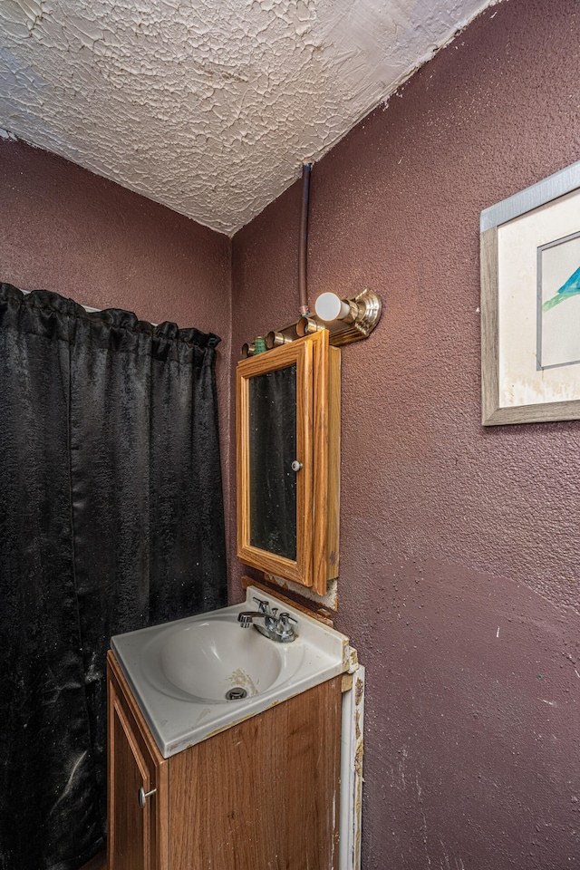 bathroom with a textured ceiling and vanity