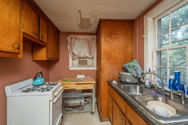 113 America St Unit A, B, C, D, Charleston, SC 29403 - kitchen with white gas range oven, a sink, brown cabinetry, and cooling unit
