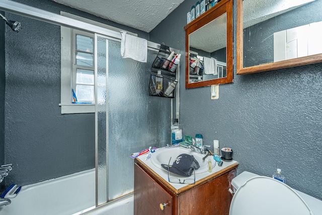 full bathroom with enclosed tub / shower combo, a textured ceiling, vanity, and toilet