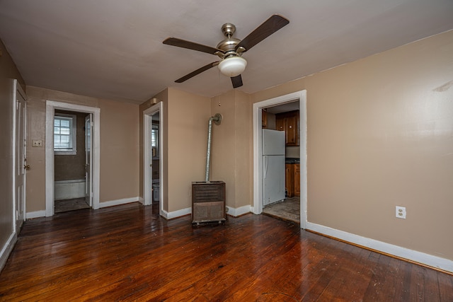 unfurnished bedroom with ceiling fan, dark wood-type flooring, ensuite bathroom, and white refrigerator