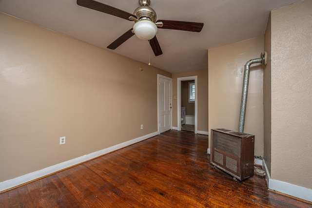 unfurnished bedroom with heating unit, dark hardwood / wood-style floors, and ceiling fan