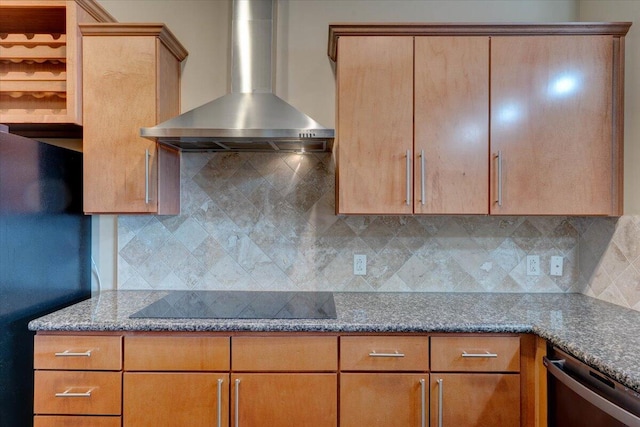 kitchen featuring black appliances, wall chimney range hood, stone counters, and decorative backsplash